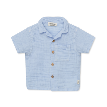 Bellissima e leggera camicia bambino in mussola di cotone biologico, firmata My Little Cozmo, in tonalità blu cielo. Maniche corte, apertura frontale tramite bottoni, colletto camp, tasca frontale applicata.