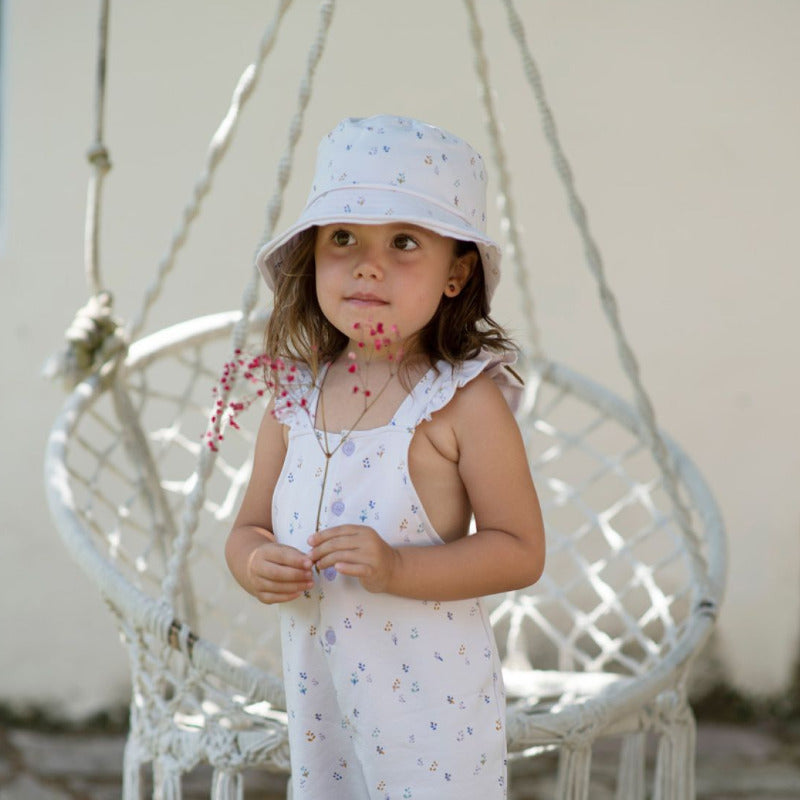 Grazioso cappello estivo per le vostre bambine in morbido e fresco cotone biologico con tanti fiorellini su fonda lavanda. Laccetti in cotone per allacciare il berretto.