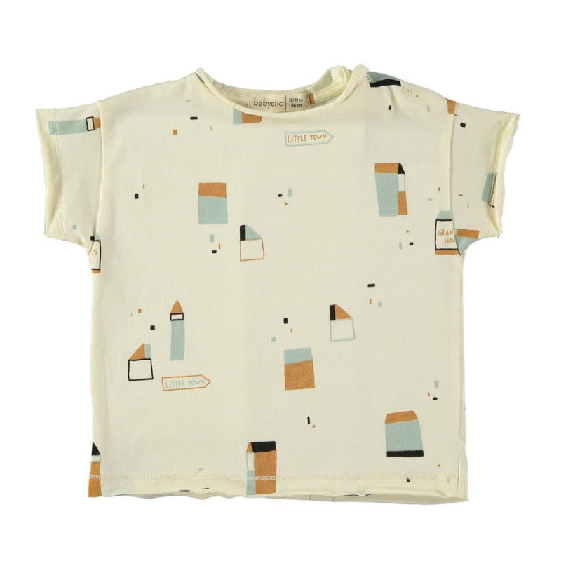 t-shirt per i vostri bambini in morbido e fresco cotone biologico a manica corta, con la stampa di una vittà stilizzata su fondo avorio. Apertura lungo spalla tramite bottoncini.