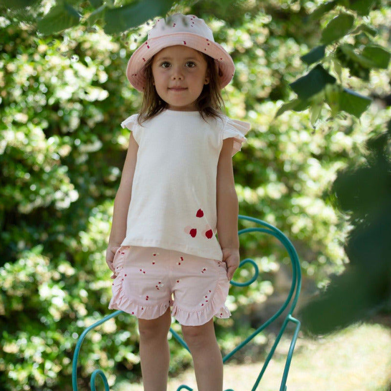 t-shirt per la vostra bambina in morbido e fresco cotone biologico a costine, in tonalità rosa con petali. Volants sulle spalle, apertura tramite bottone ad altezza collo nella parte posteriore.