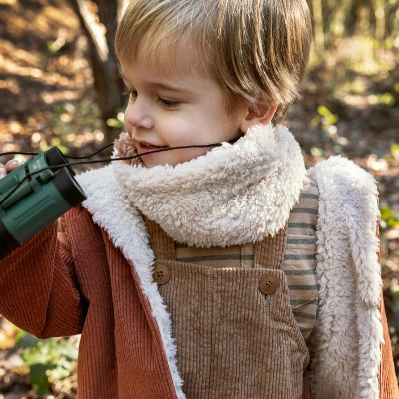 Un bellissimo cappotto in morbido velluto a costine, perfetto per tenere al caldo il corpo dei vostri bambini. Questa giacca è fornita di cappuccio e ha un'apertura frontale tramite bottoni in bio resina. L'interno è in morbida fodera di eco pelliccia.